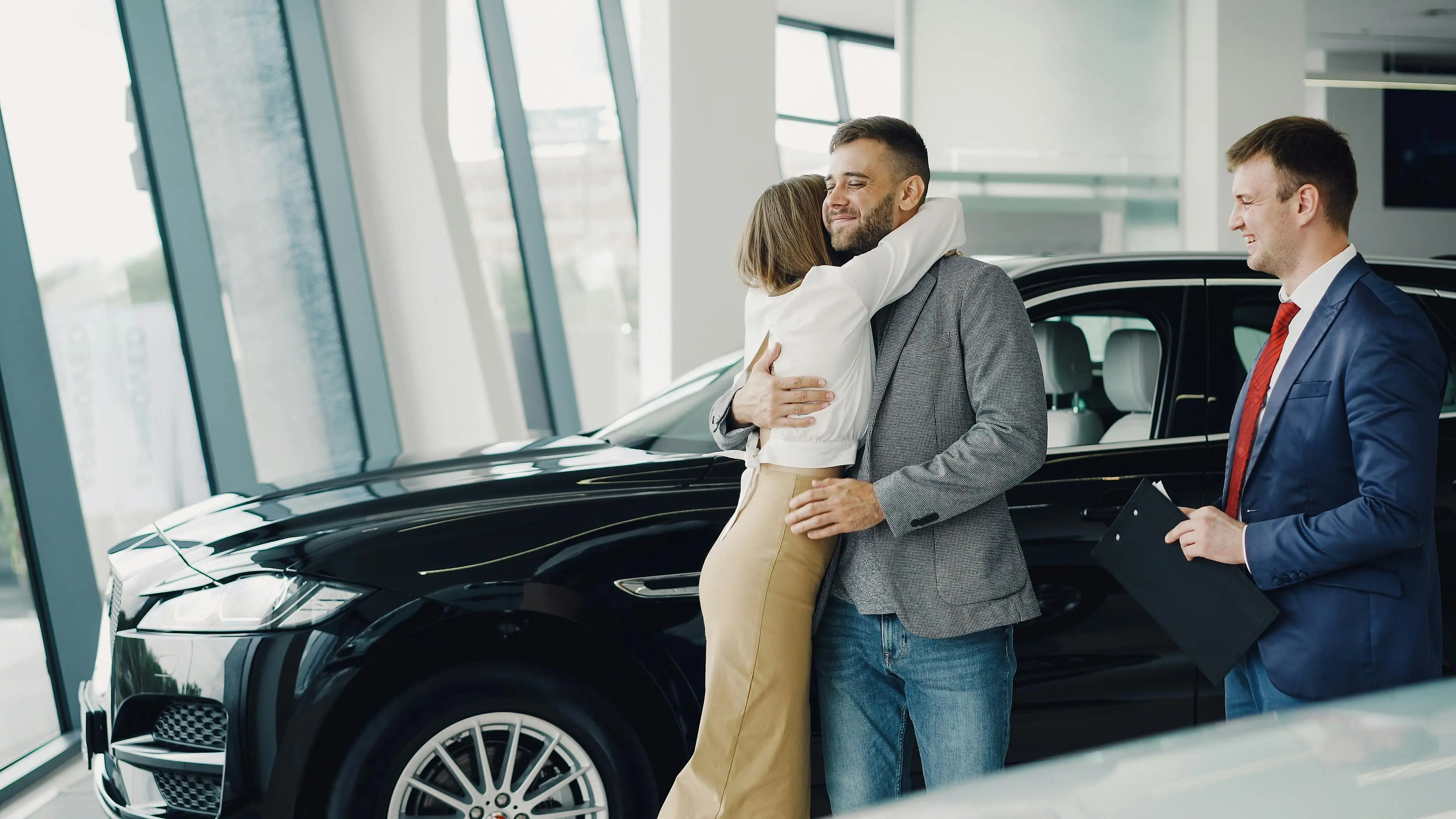 Customers celebrating a vehicle purchase with their salesperson at the dealership
