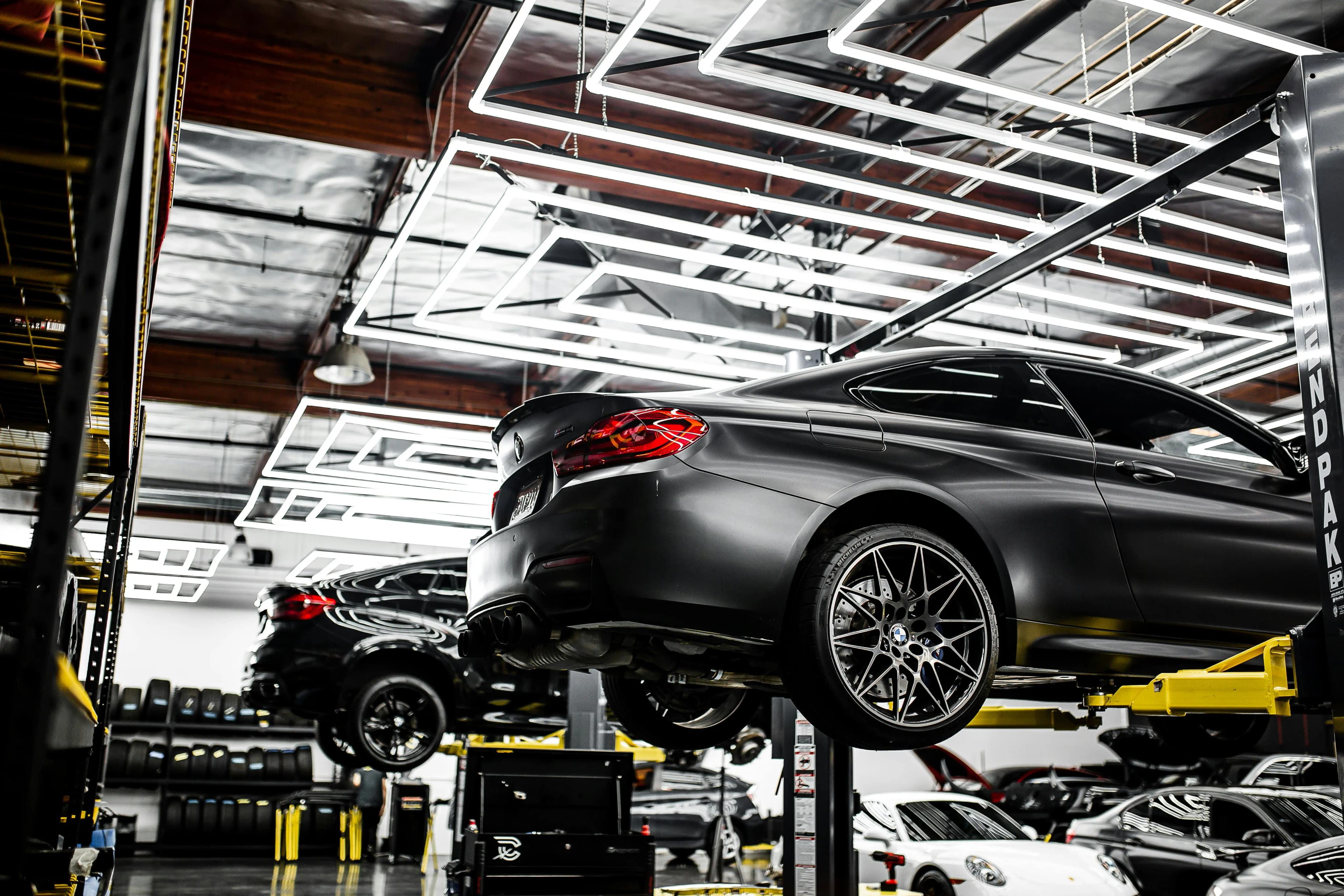 Vehicles on lifts on a busy dealership service drive
